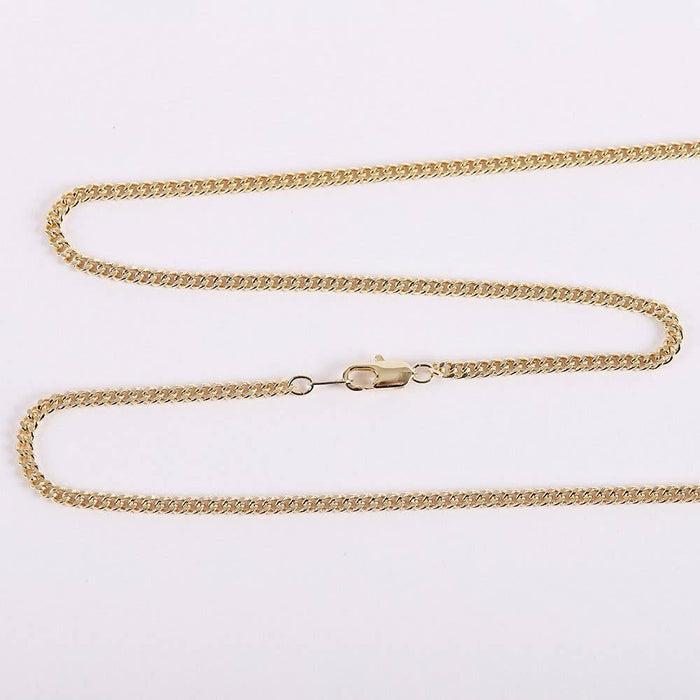 Gold chain necklace on a light gray background