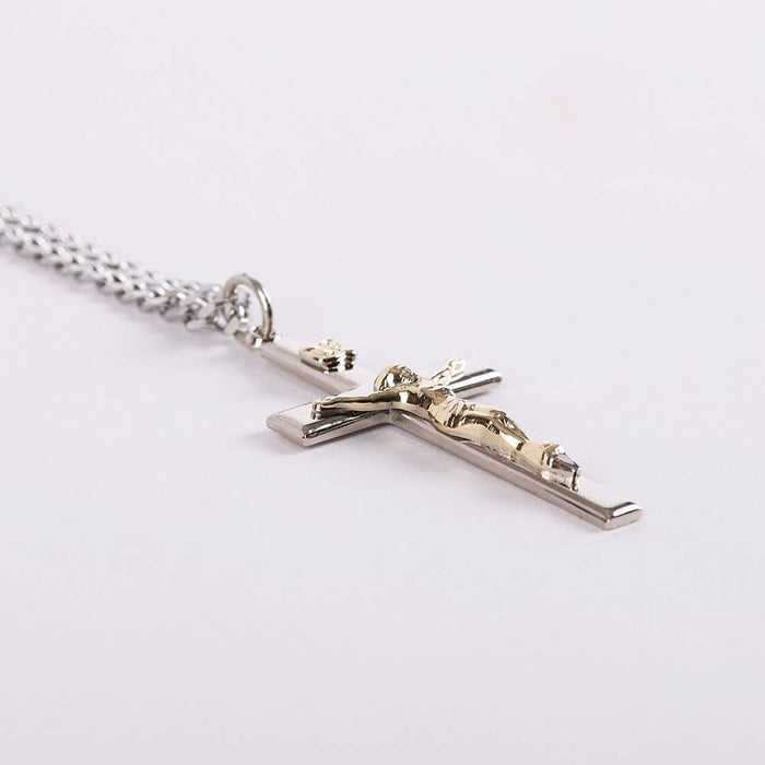 Silver cross pendant with Jesus figure on a white background
