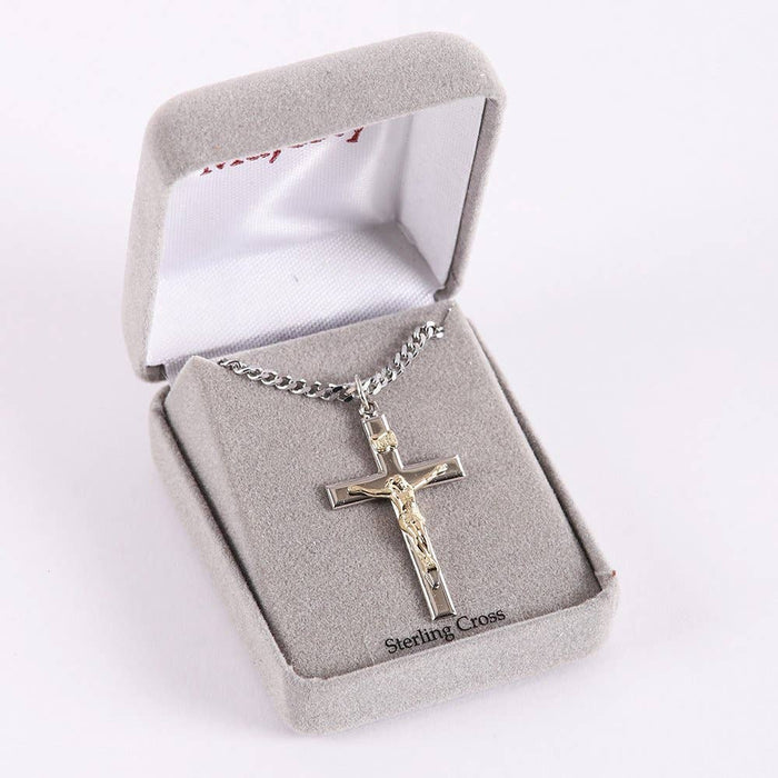 Silver crucifix necklace in a gray jewelry box with 'Sterling Cross' branding.