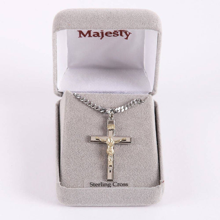 Silver crucifix necklace in a 'Majesty' branded box on a white background