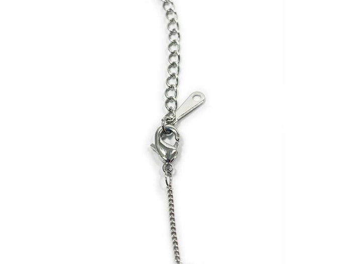 Close-up of a silver chain necklace on a white background