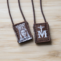 Scapular with religious symbols on a light wood surface