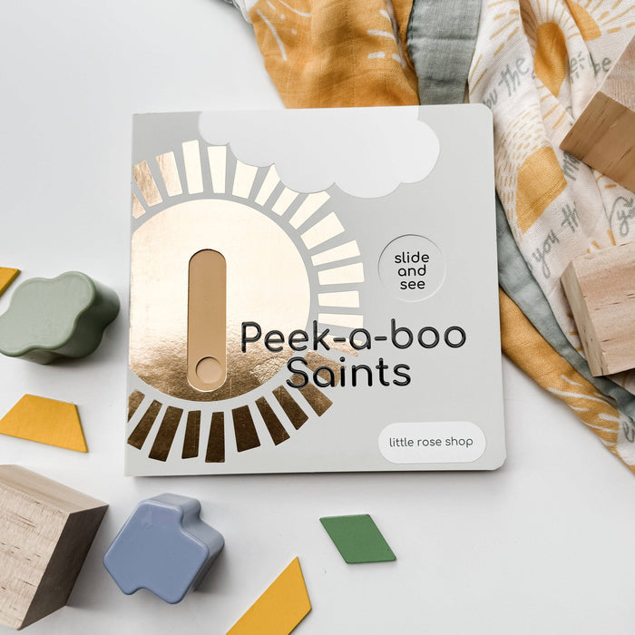 Packaging of 'Peek-a-boo Saints' toy with wooden shapes on a light background