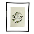 Framed artwork with a wreath design and text on a white background
