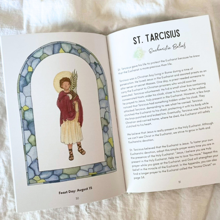 Open book with illustration of St. Tarcisius and text on a white surface