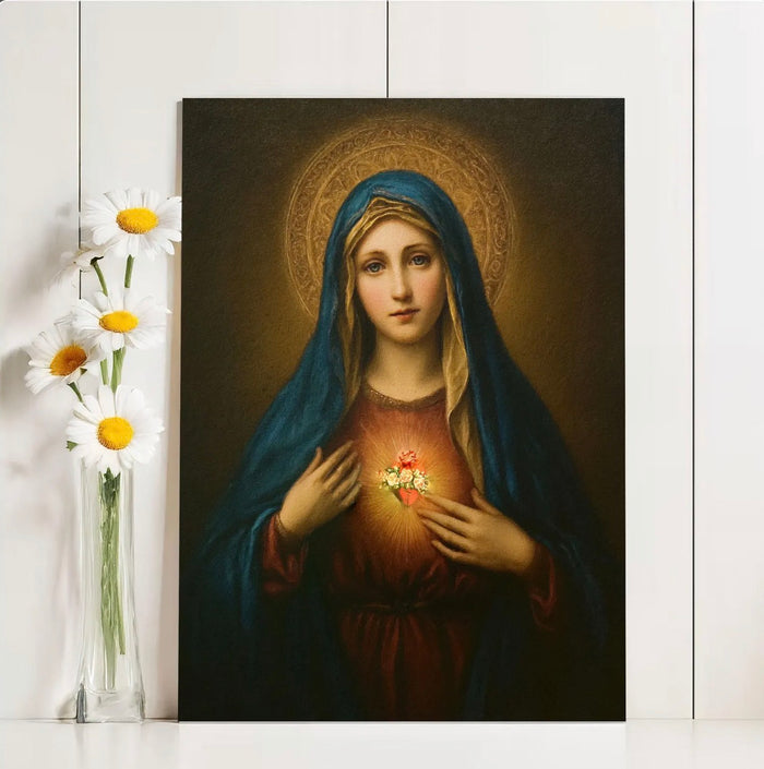 Painting of a Mary  with a heart in front, next to a vase of flowers on a white surface.
