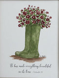 Framed artwork of a green boot with flowers on a beige wall