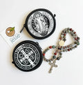 Two round black pouches with white designs and a rosary on a white background.