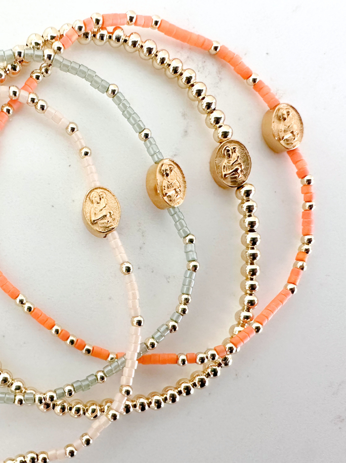 Set of beaded bracelets with gold accents on a light background