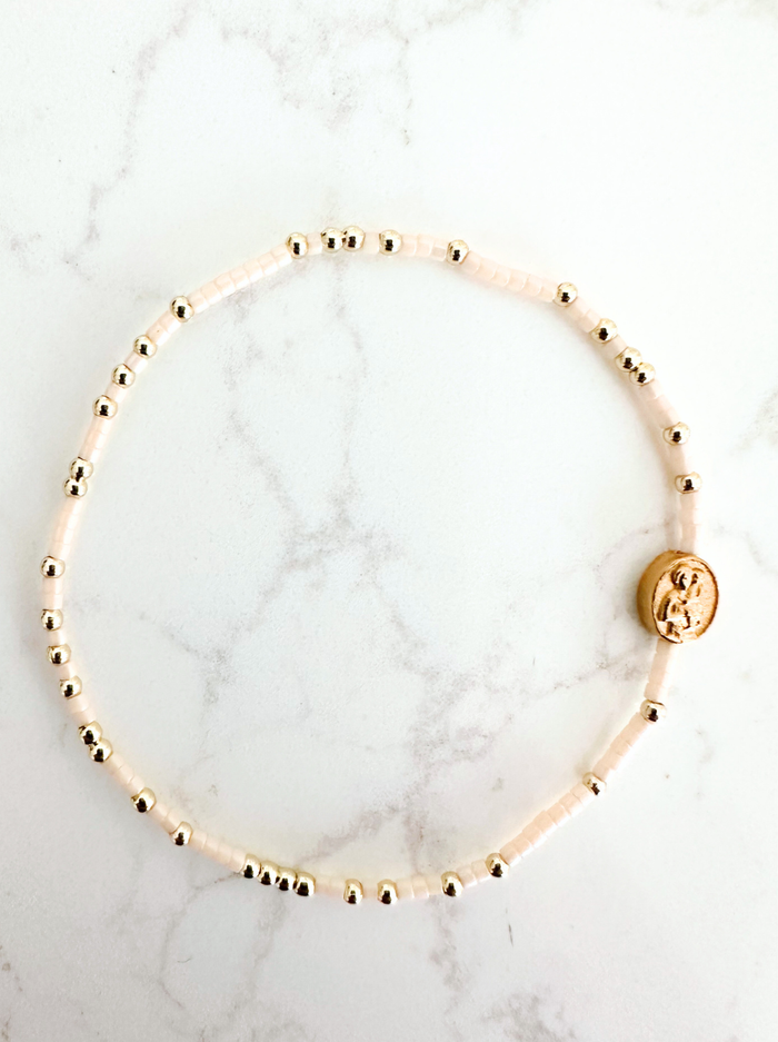 Gold beaded bracelet on a marble surface