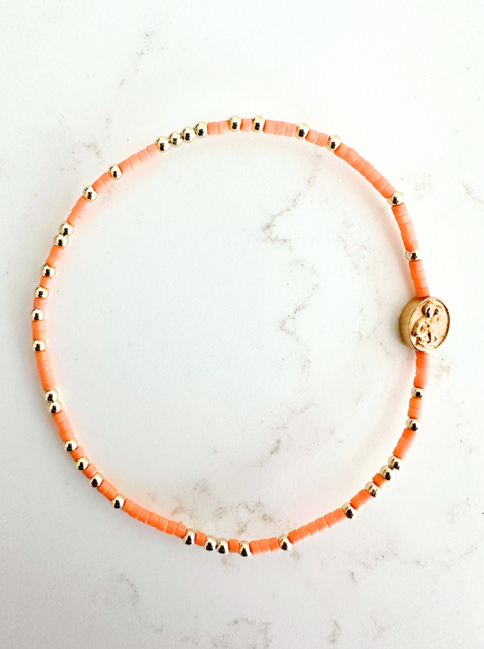 Bracelet with orange beads on a marble surface