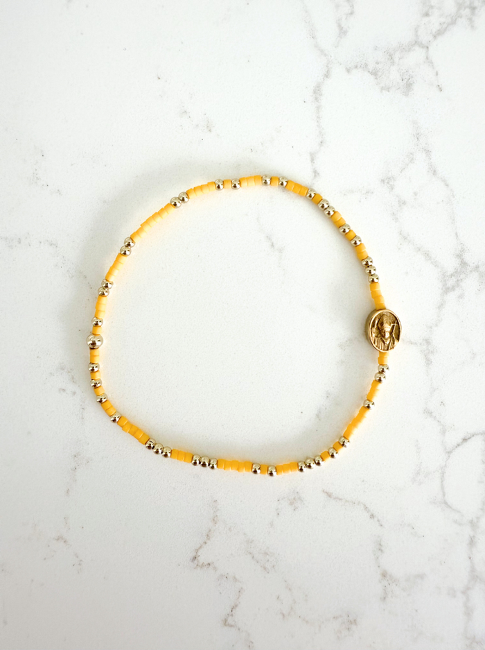 Yellow beaded bracelet on a marble surface