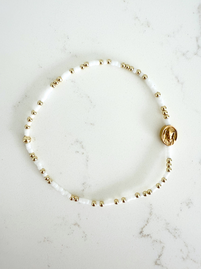 Pearl bracelet with gold beads on a marble surface