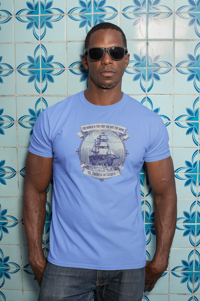 Man wearing a light blue t-shirt with a graphic design against a blue tiled wall.