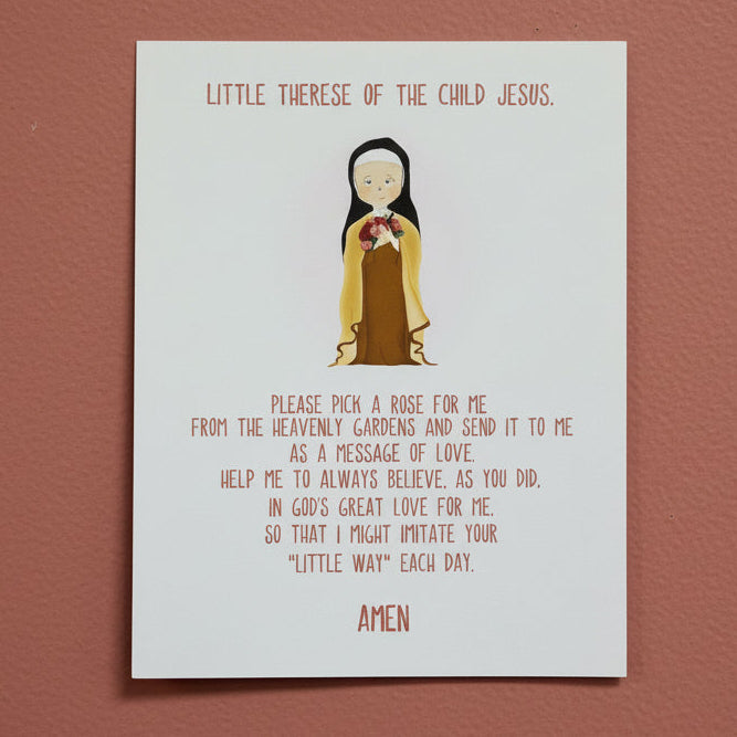 Print with an illustration of a St. Therese and text on a white surface