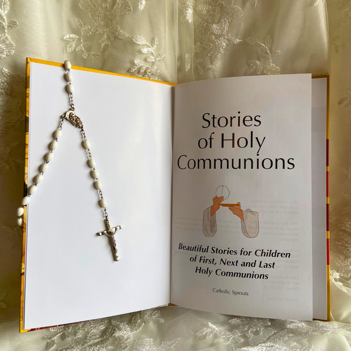 Open book titled 'Stories of Holy Communions' with a rosary on top, against a textured beige background.