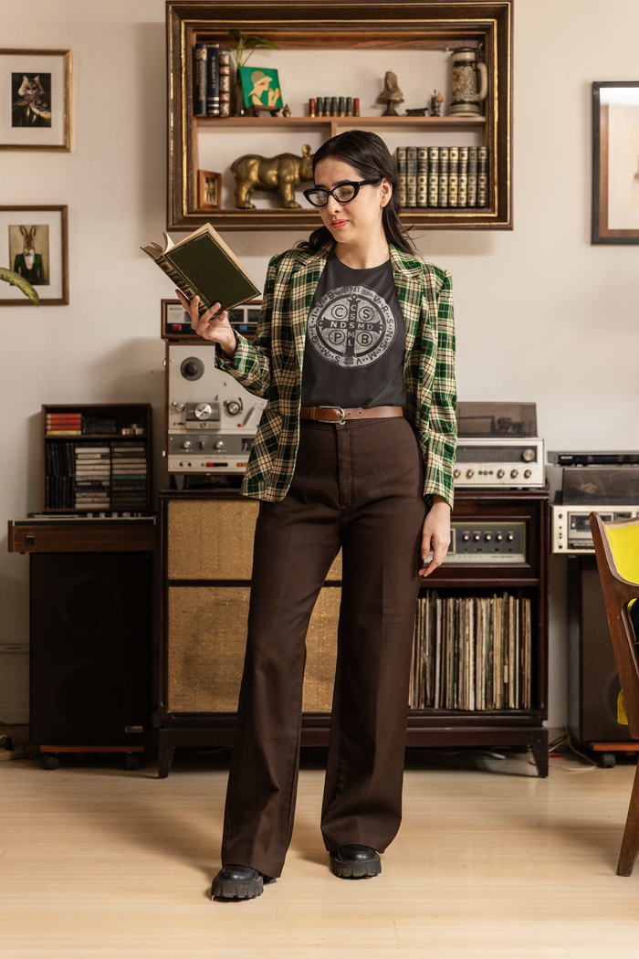 Person holding a book in a room with vintage stereo equipment and bookshelves.