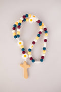 Colorful beaded rosary with wooden cross on a light gray background
