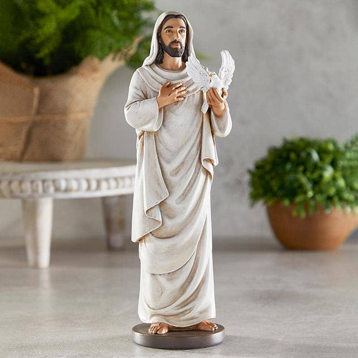 Statue of a jesus holding a dove in a home setting with plants.