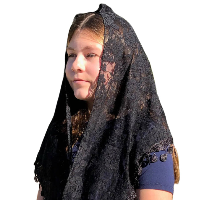 Person wearing a black lace veil on a white background