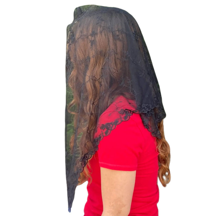 Person wearing a black lace veil on a white background