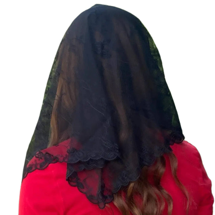 Person wearing a black lace veil on a white background