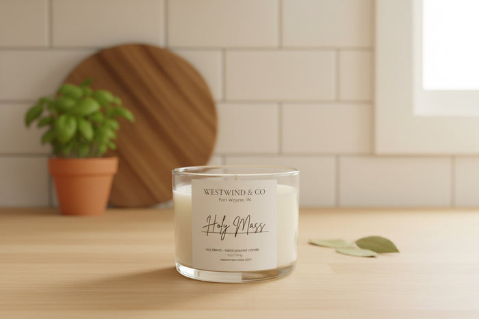 Candle with 'Westwind & Co' label on a wooden surface with a plant in the background
